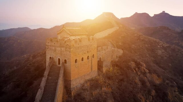Aerial shot of the Great Wall of China at sunset on a hazy day.