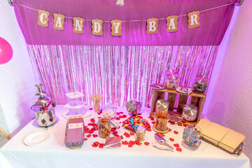 Candy bar pink wedding decorated standing of festive table with deserts, strawberry tartlet and cupcakes