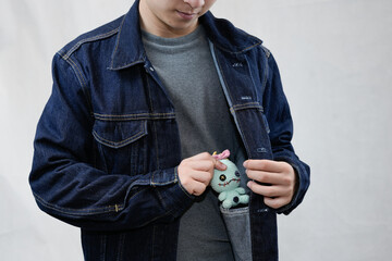 cute creepy voodoo crochet in denim jacket pocket with model