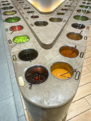 a counter with different sauces in a chinese food restaurant, stainless steel countertop with tasty sauces for asian food