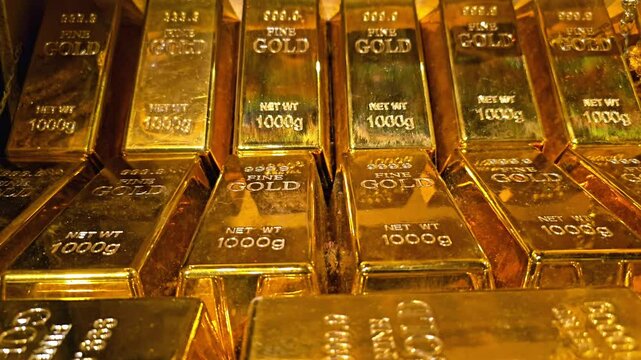 Stack of gold bars with 1000g weight markings. Close-up view of multiple gold bullion bricks arranged in rows. Wealth, investment, and banking concept