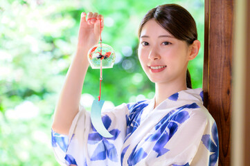 浴衣姿の女性が夏の涼を感じながら風鈴を手にする時間