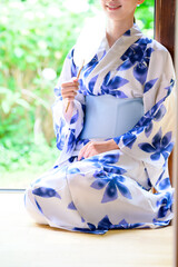 縁側で団扇を手に浴衣姿の女性が見せる和の落ち着き