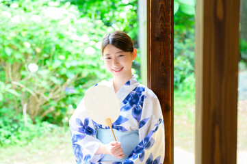 浴衣姿の女性が団扇を手に見せる穏やかな夏の笑顔