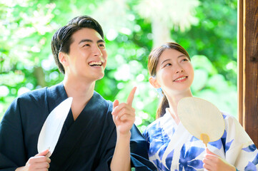 浴衣姿の男女が団扇を手に笑い合う夏の楽しい一瞬