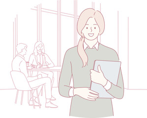 A confident woman in a modern office holds a folder as colleagues engage in discussion, fostering collaboration