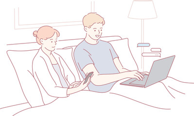 A couple enjoying a cozy evening while using their devices in bed, highlighting modern technology use.