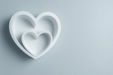 Two nested white heart shapes on pale background