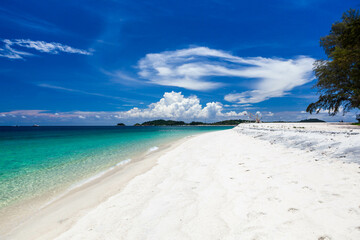 Koh Adang, Thailand. Crystal-clear emerald color Andaman sea meets pristine sandy beach under blue...