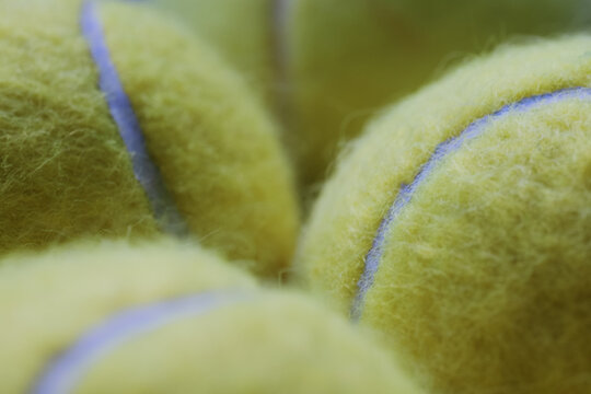 Extreme Close-up detail macro shot of tennis balls in dramatic lighting in Fluorescent, Optic yellow or Electric lime colour, showing fuzzy covering. Sports Equipment. Ball Sport and Game concept.