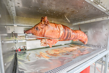 Barbecue with young pig grill Whole roasted piglet body turning on grill. Large barbecue in the process of cooking meat