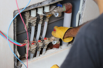 
Technician adjusting radiant floor heating valves
