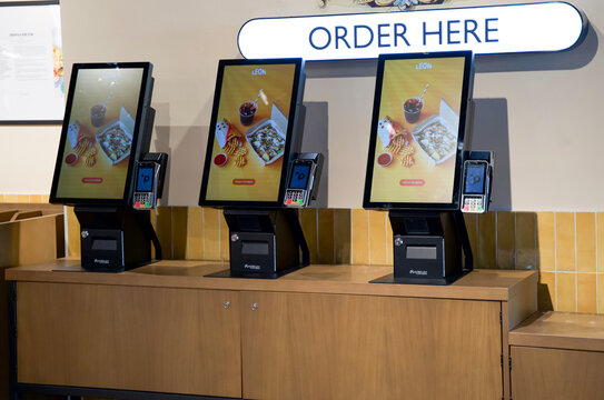 Rome, Italy - April 10, 2025: Self-service kiosks for ordering food in a modern restaurant with digital screens and payment options available