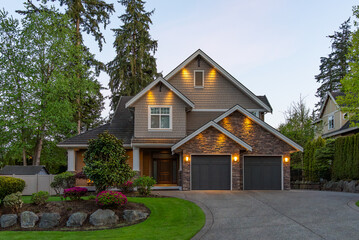 Two story stucco luxury house with nice Spring blossom landscape at night in Vancouver, Canada, North America. May 2025.