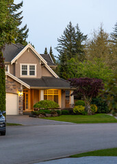 Two story stucco luxury house with nice Spring blossom landscape at night in Vancouver, Canada, North America. May 2025.