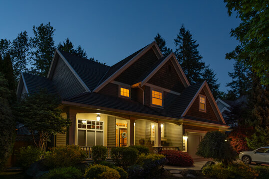 Two story stucco luxury house with nice Spring blossom landscape at night in Vancouver, Canada, North America. May 2025.