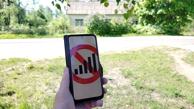 A man in the summer with a phone that has no signal