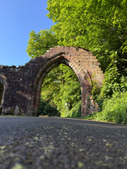 Medieval stone arch of Furness Abbey catching sunlight in Cumbria.
