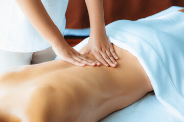 Caucasian woman customer enjoying relaxing anti-stress spa massage and pampering with beauty skin recreation leisure in day light ambient salon spa at luxury resort or hotel. Quiescent