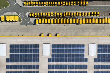 Delivery vans hub with solar panel on a roof. Fleet of yellow post vehicles
