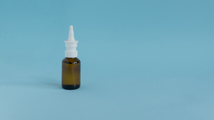 A bottle of medicinal liquid for stopping a runny nose on a light blue background. Pastel colors....