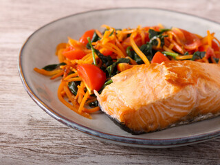 Salmon with carrot and spinach on plate