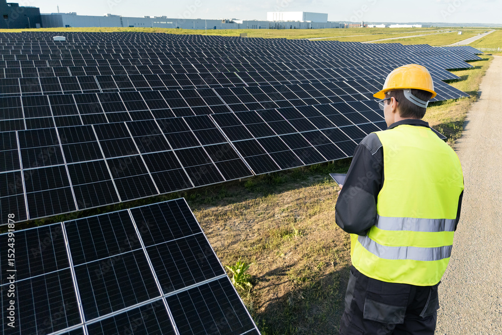 Poster engineer with tablet computer on a solar energy power station