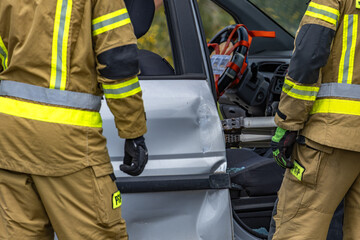 Firefighters and rescuers cut open a car body during a rescue operation,