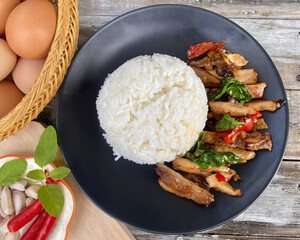 Grilled Chicken with Thai Basil and Rice &ndash; Spicy Asian Stir-Fry Dish on Black Plate