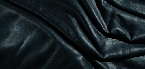 Draped black leather texture with soft folds and wrinkles.