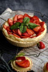 Homemade Strawberry Tart with Cream and Mint on Rustic Background