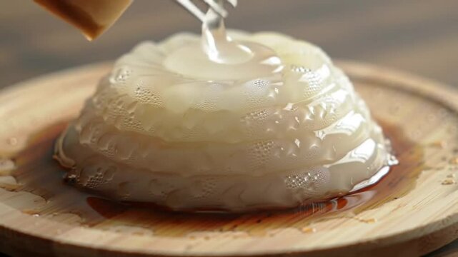 Raindrop cake with kuromitsu syrup, delicate wobble on bamboo plate