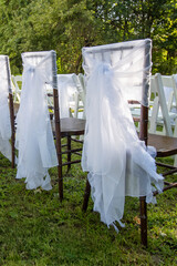 chairs decorated for a wedding with white tulle