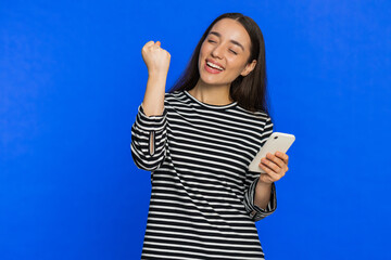 Happy excited Caucasian young woman girl use smartphone typing browsing shouting say wow yes found...