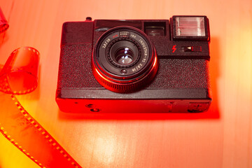 Old 35mm film camera, vintage analog in classic retro style, with 3 5mm negative photographic film...