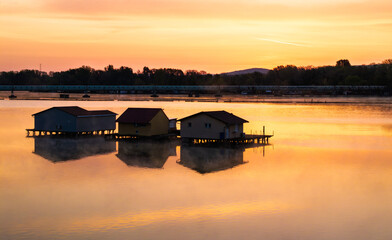 Floating village at sunset in Hungary showcases tranquil water reflections
