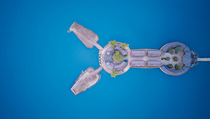 Panoramic view of an island with stone structures surrounded by clear blue water