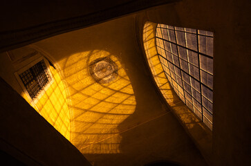 Light creates intricate shadows on an architectural surface in a historic building