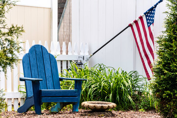 Adirondack chair and American flag in backyard 
