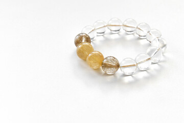 Golden rutilated quartz and clear quartz bracelets on the table.