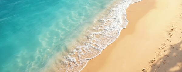 Obraz na płótnie Canvas Aerial view of a beach with light blue transparent water. Gentle waves wash over the golden sand. Summer vacation background with space for text, relaxation, spa and well-being.