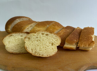 Close-up of sliced artisan white bread on a wooden board with rustic fabric background. Fresh...