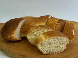 Close-up of sliced artisan white bread on a wooden board with rustic fabric background. Fresh...