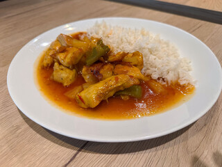 Delicious chicken sweet and sour with white rice on wooden table