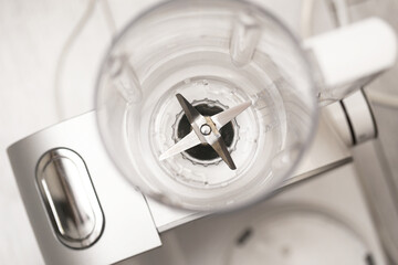 Top view of blender. Empty plastic jug with sharp blades. Kitchen appliance ready. Home cooking preparation. Clean white equipment. Modern culinary tool. Food processor device.