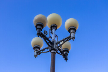 Low angle, abstract view of a 20th century ornamental street lamp, with clear blue sky background