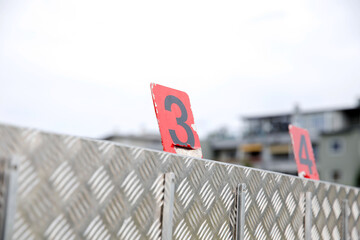 Metallic surface with red number markers in urban setting