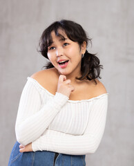 Portrait of smiling asian girl in casual clothes posing in studio