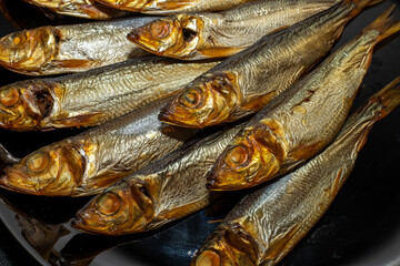 Tasty and salty smoked sprats marinated with salt and spices. Smoked fish marinated with herbs and salt. Smoked fish herring.