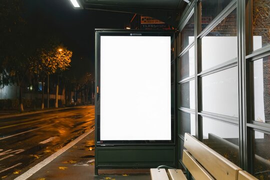 Mock up of blank advertising billboard or light box showcase poster template on city bus shelter.